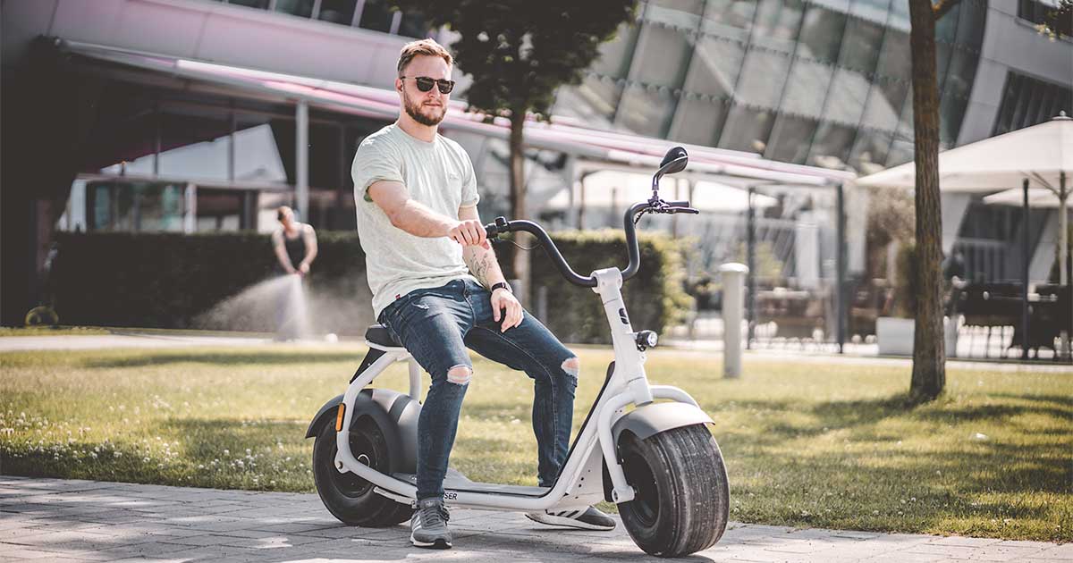 Mies ja istuttava sähköpotkulauta