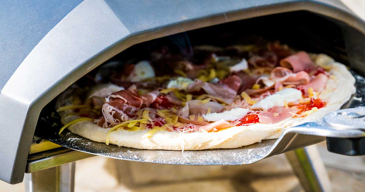 Pizza työnnetään pizzauunin sisälle raakana