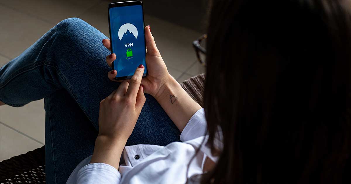 Nainen käyttää puhelinta jolla on asennettu VPN-sovellus